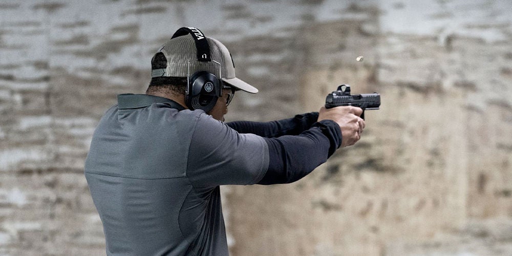 A man aiming a gun at a target, focusing on marksmanship skills to effectively stop a threat with proper bullet placement.